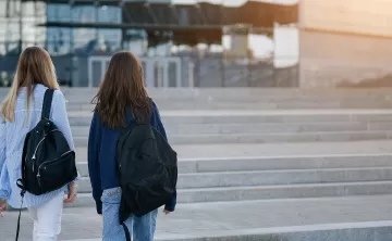 Two young people walking outside with backpacks 