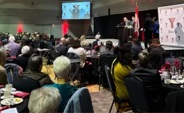 People sitting at tables watching the speaker talk at PeaceMedal