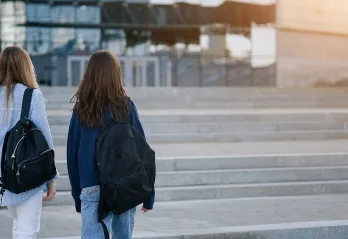 Two young people walking outside with backpacks 