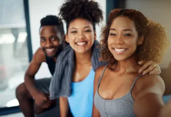 Three young adults take a selfie after a workout