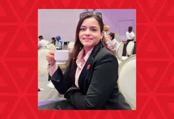 woman holding coffee cup sitting at table