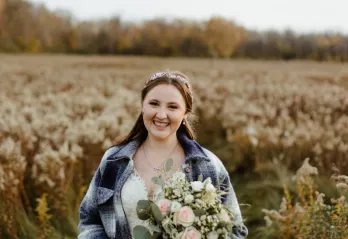 bride in field wearing blue flannel