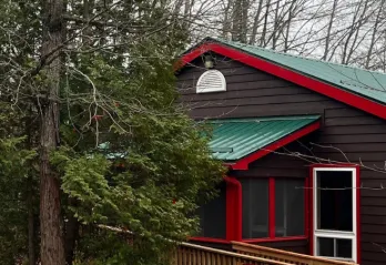 Brown cabins with forest green steel roofs and red trim
