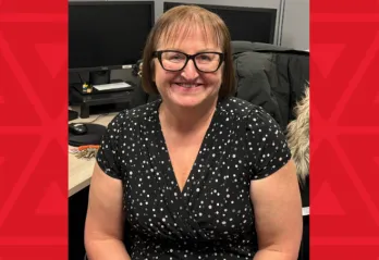 women in black dress sits at desk