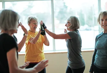 senior women high fiving in gym class