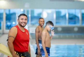 Lifeguard and two boys in front of the pool