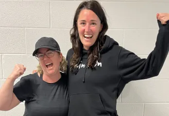 two women wearing black, cheering