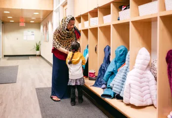 Woman and Child Near Coat Cubbies 