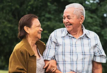 Two older individuals walking together and smiling