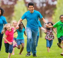 Group of individuals of all ages running and holding hands