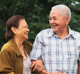 Two older individuals walking together and smiling