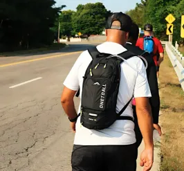 Individuals walking down side of a road