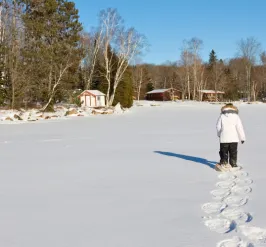 Snowshoer trekking across frozen lake