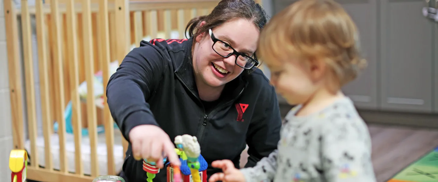 Male preschool child and Educator playing with colourful toys