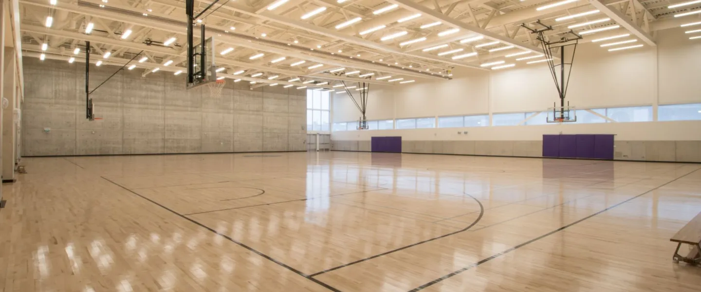 Double gym with basketball nets and retractable seating