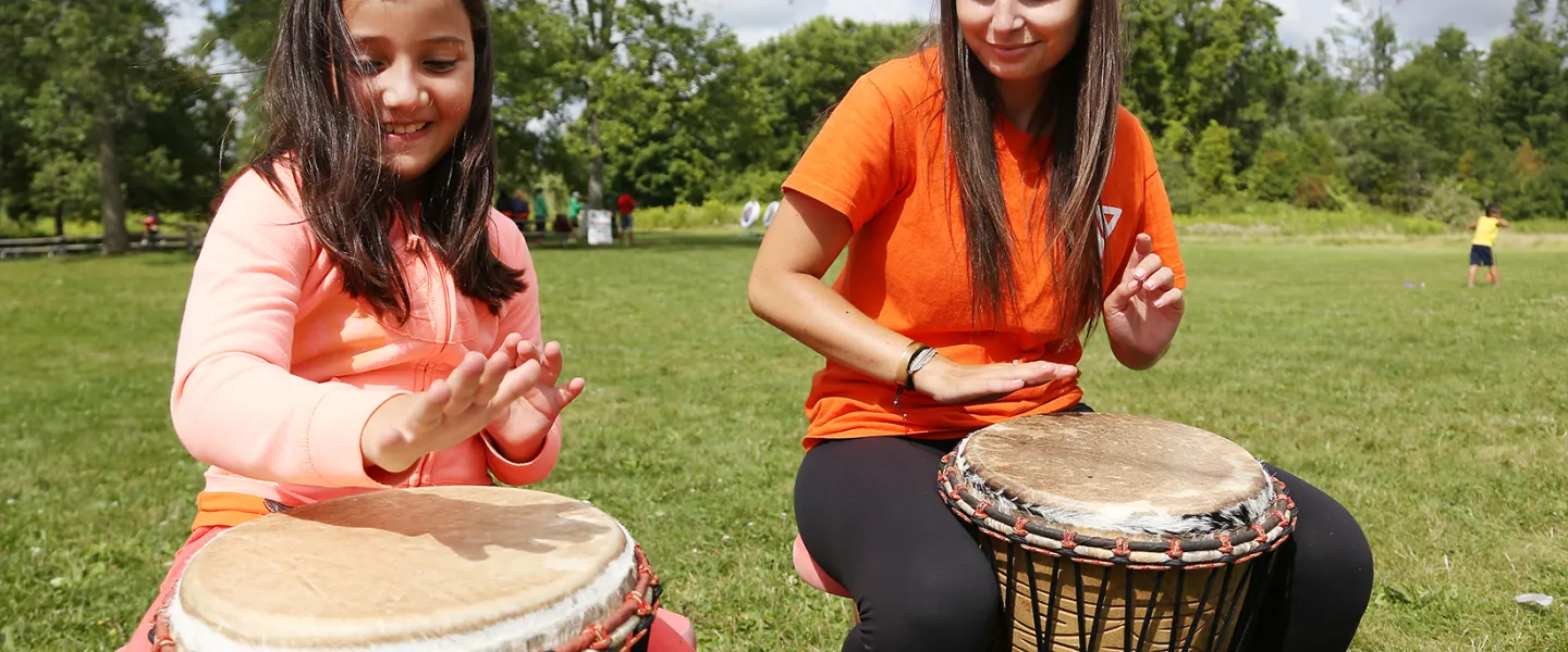 Camper and Counsellor beating on drums