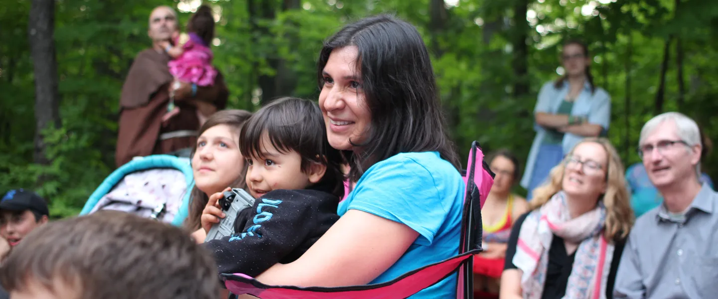 Mother and son sitting around group camp fire