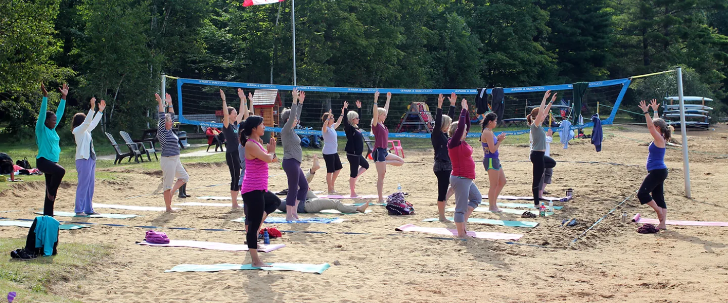 Families participating in Yoga on the sandy shore