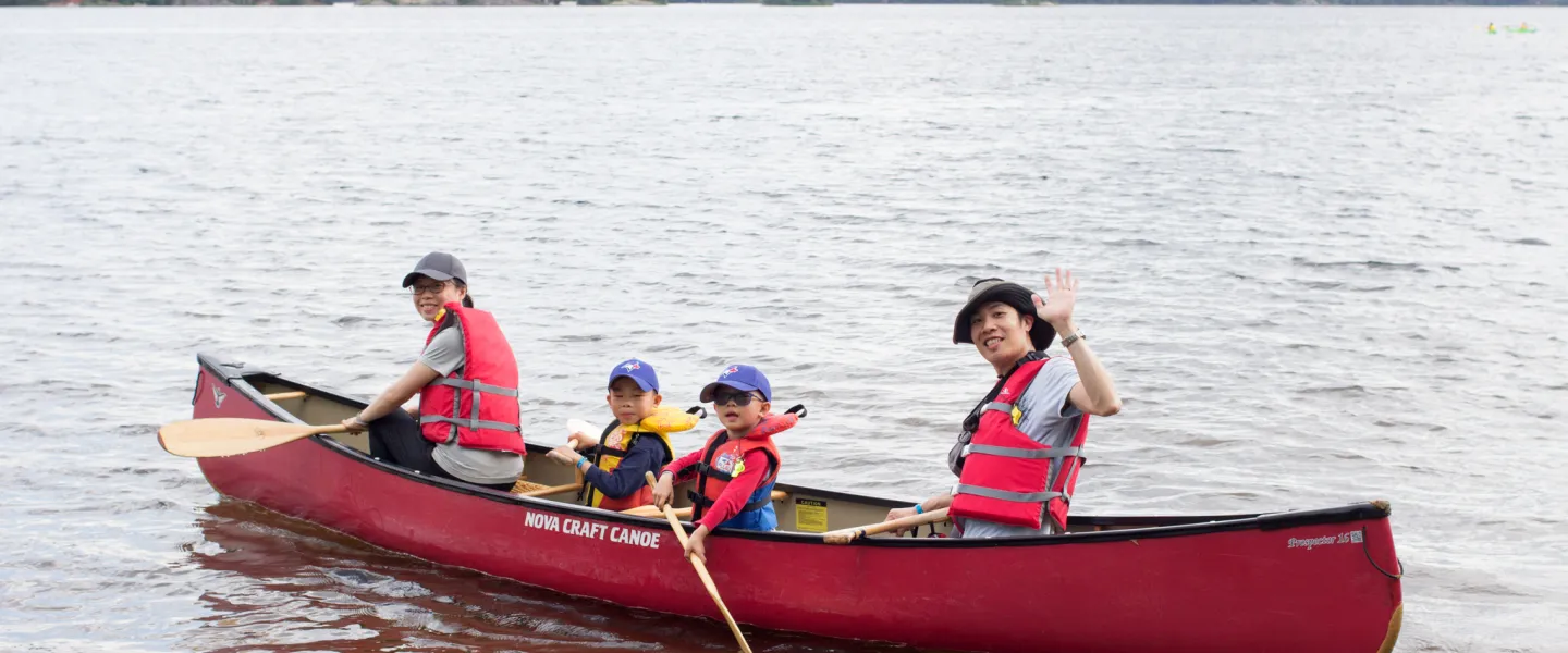 Smiling family in canoe at Wanakita on Koshlong Lake