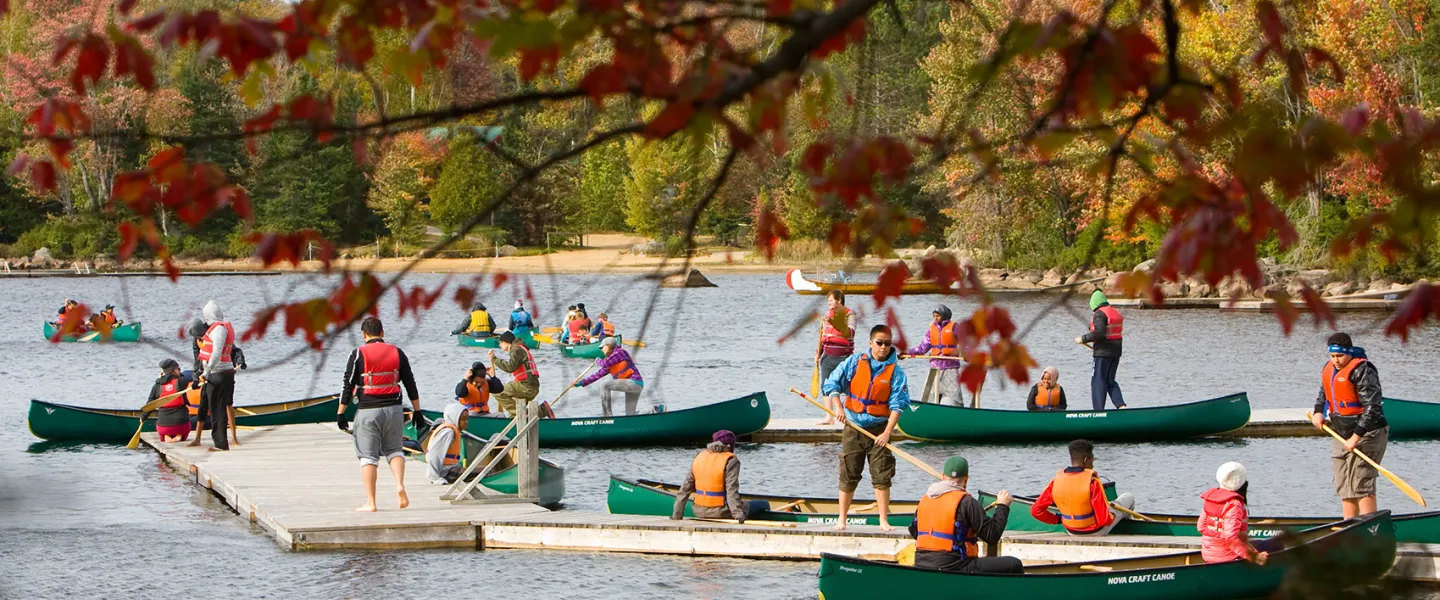 Youth in canoes around dock area