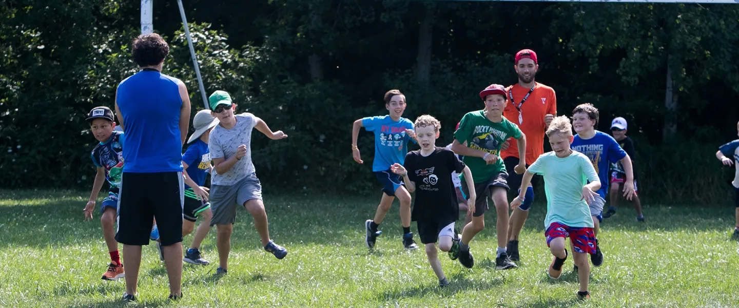 Group of campers playing soccer in grass