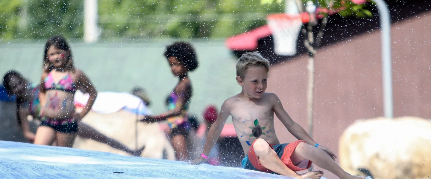 Day Camp children participating in slip and slide water activities