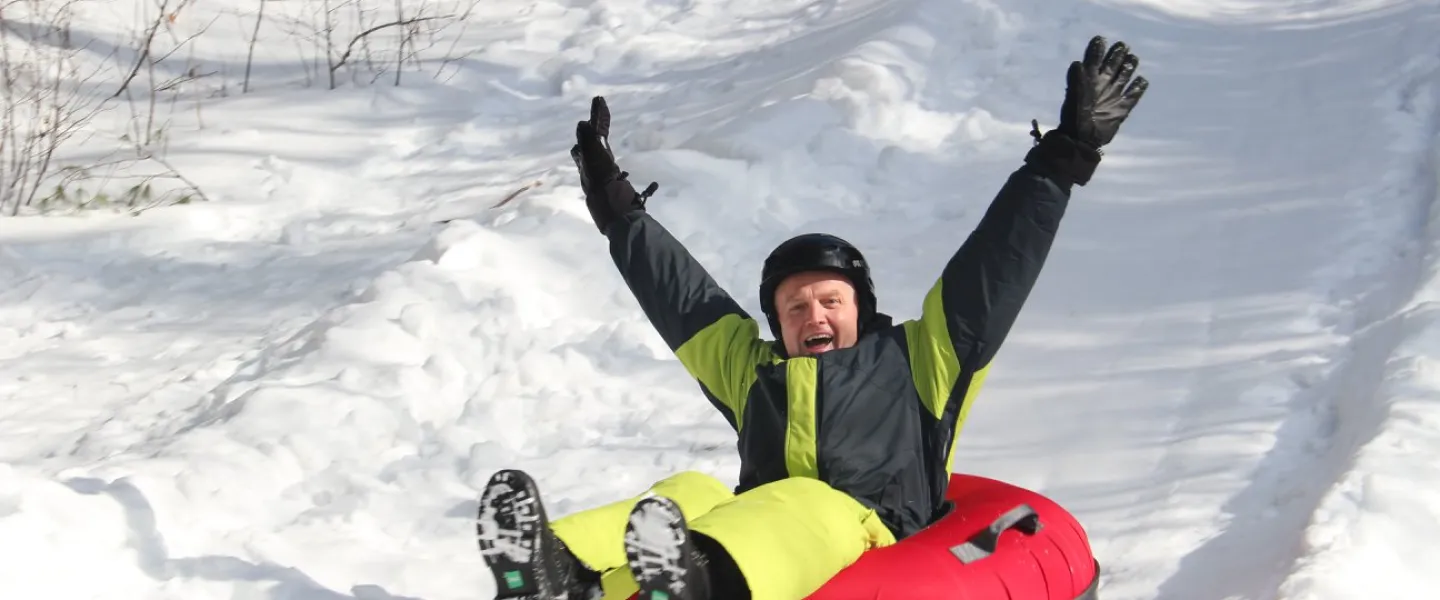 Adult tobogganing down hill