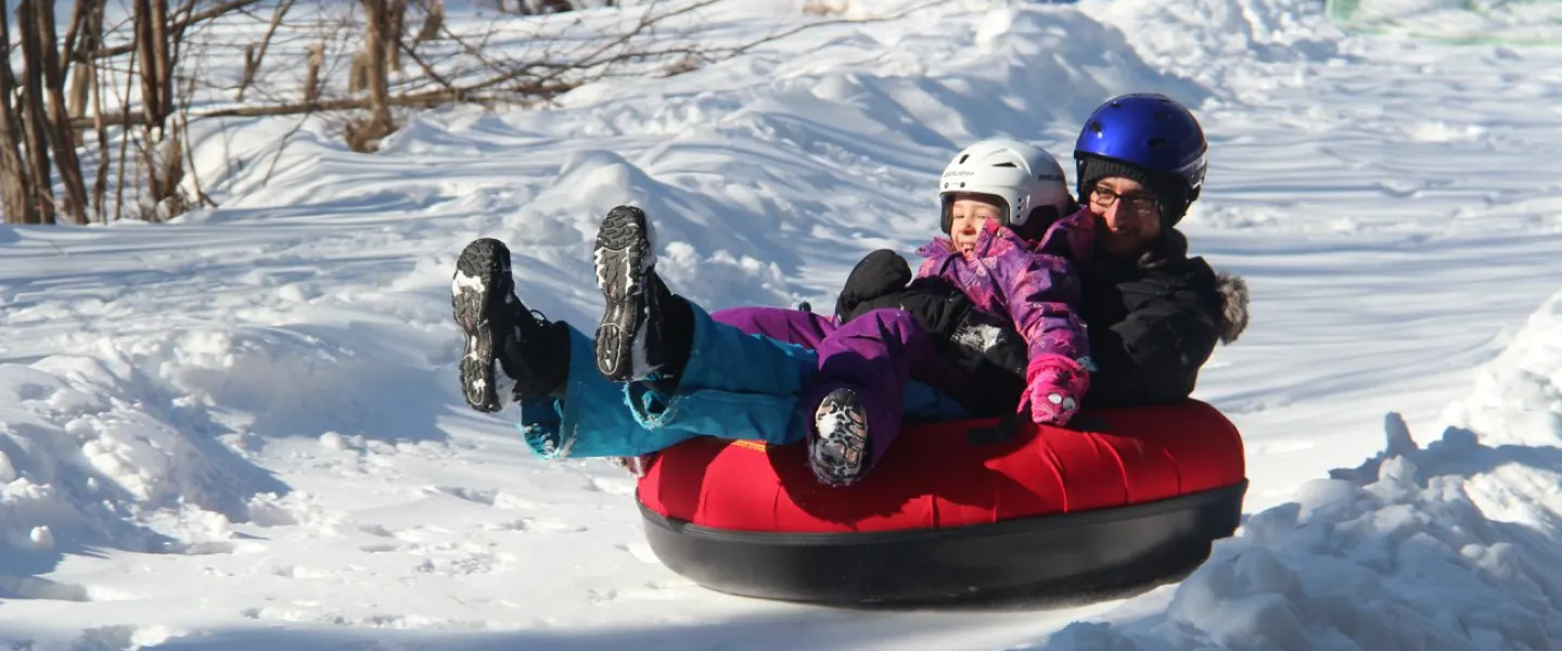 Child and parent tobogganing at camp