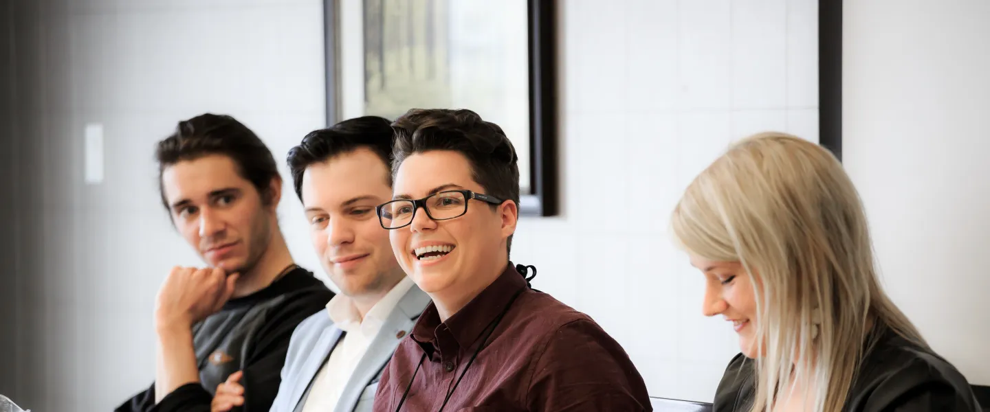 Four people sitting down at a table.
