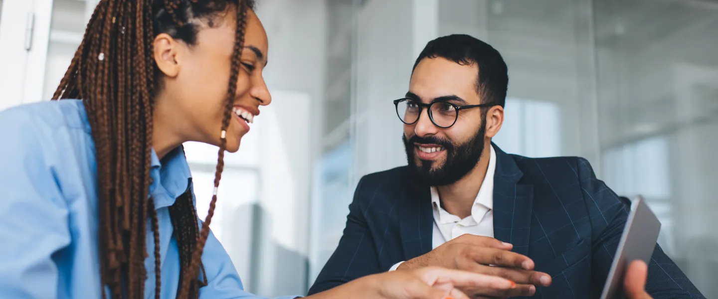 Two people looking at computer talking, smiling