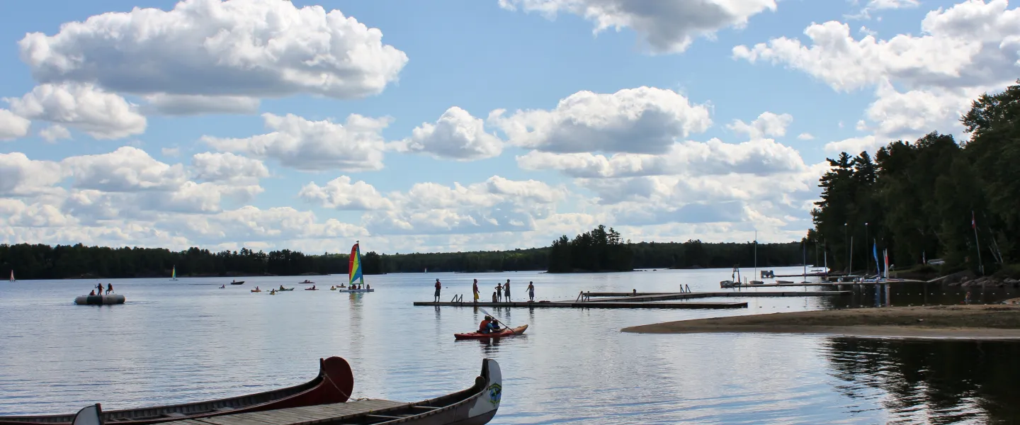Koshlong Lake waterfront with campers on the dock and wind surfing