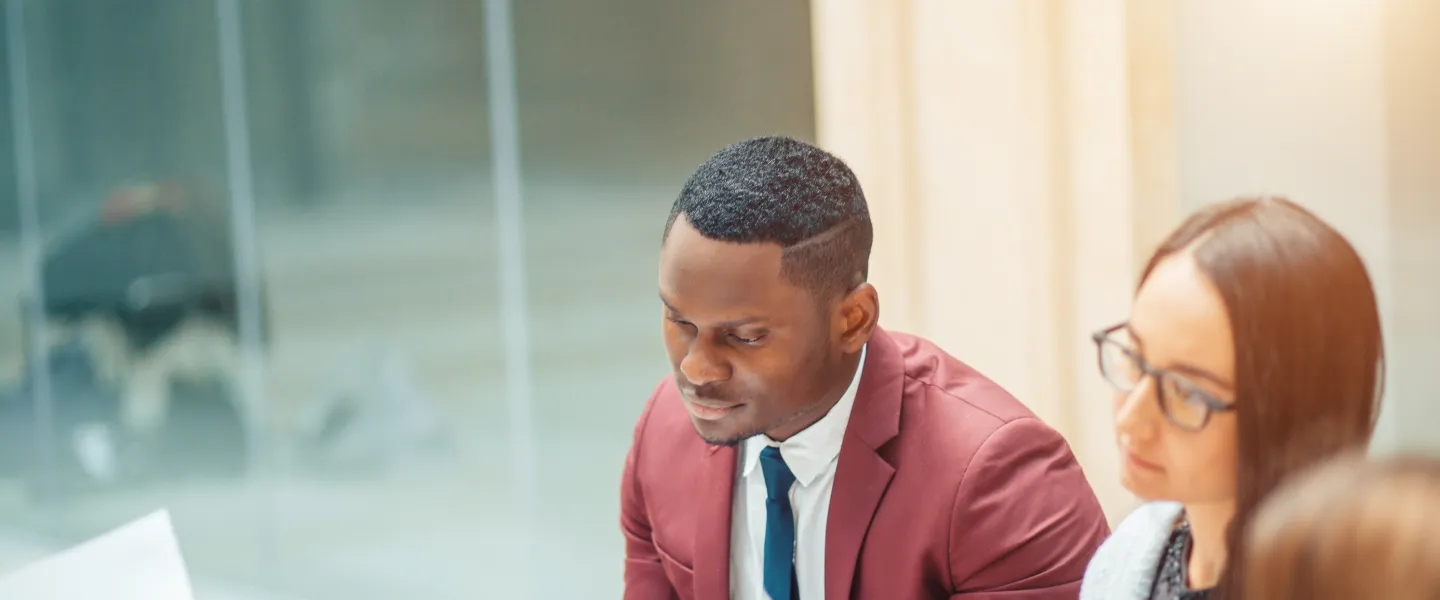 Two young people dressed professionally reviewing paperwork together