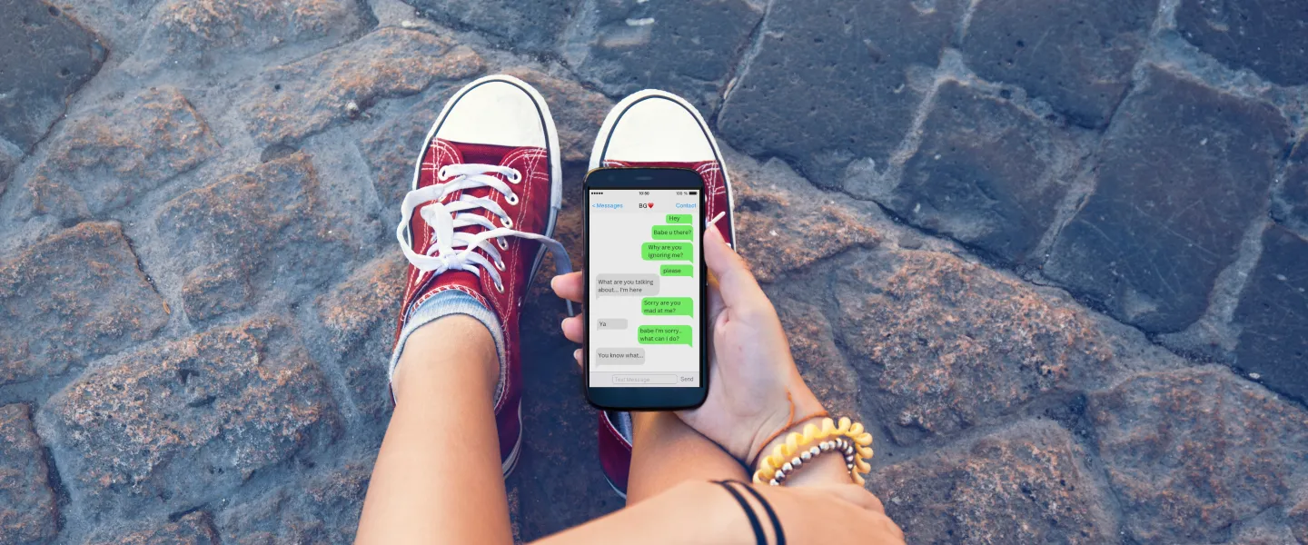 young person looking at phone. The phone screen shows text messages with someone who they are having an argument with.