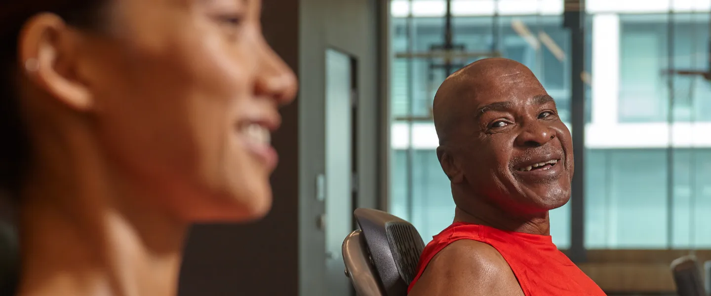 Two individuals smiling while at a gym