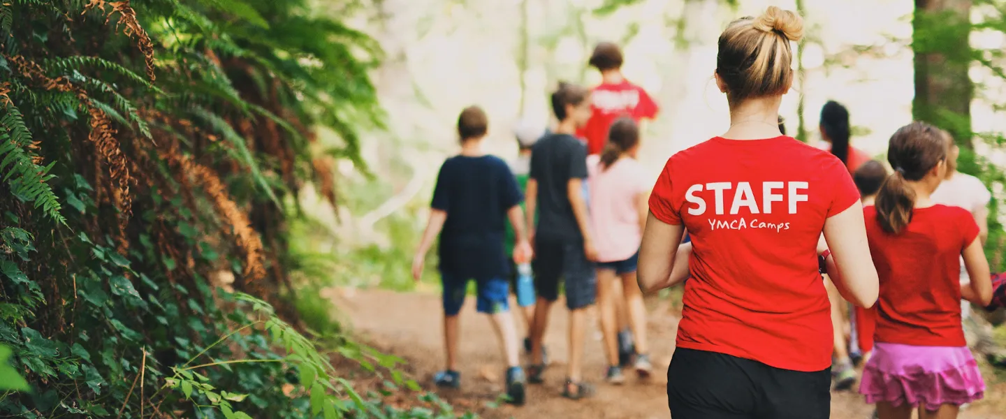 Camp councilors and kids walking down a path