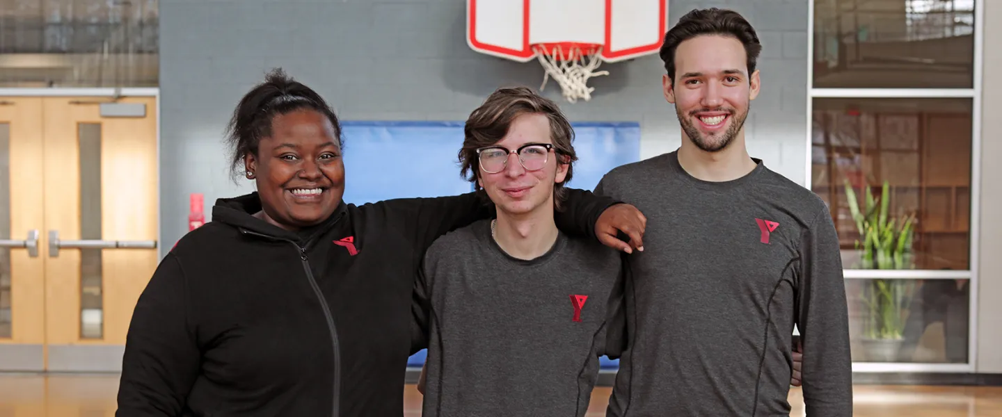 Young YMCA staff posing and smiling in main gym