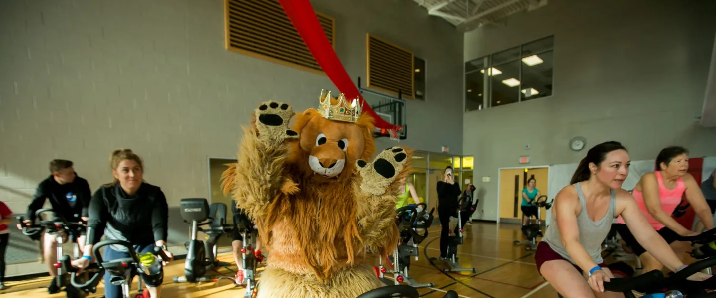 Adult members indoor cycling at fundraising event