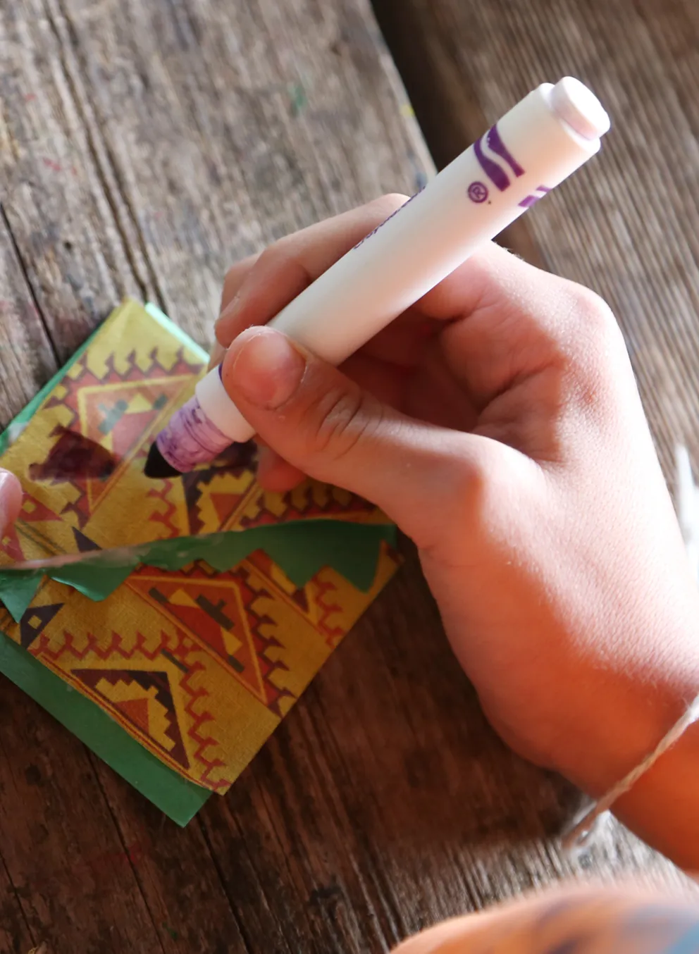Close-up of hands making a craft with markers