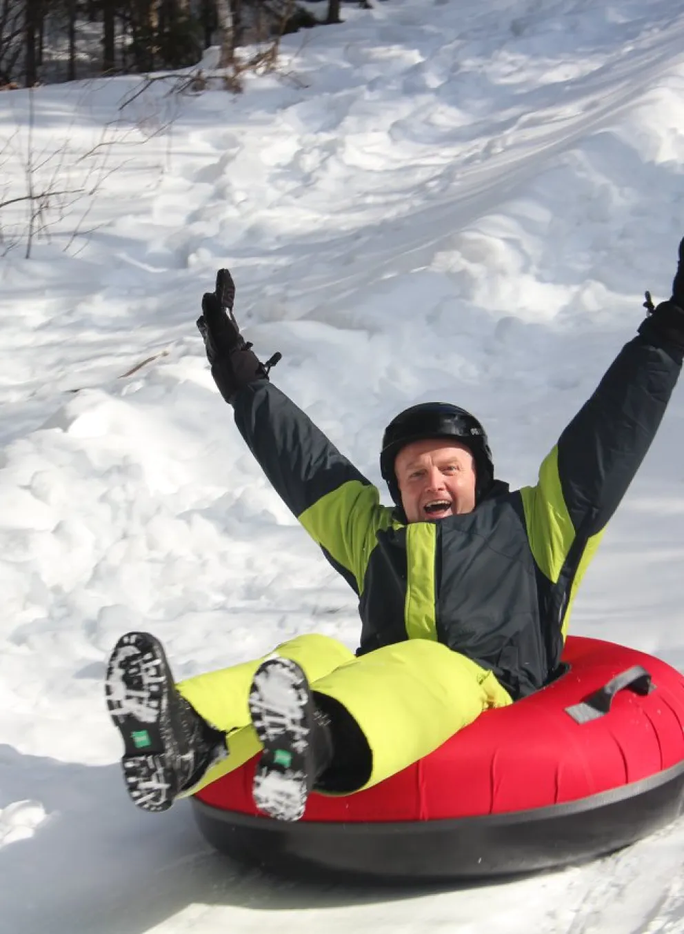 Adult tobogganing down hill