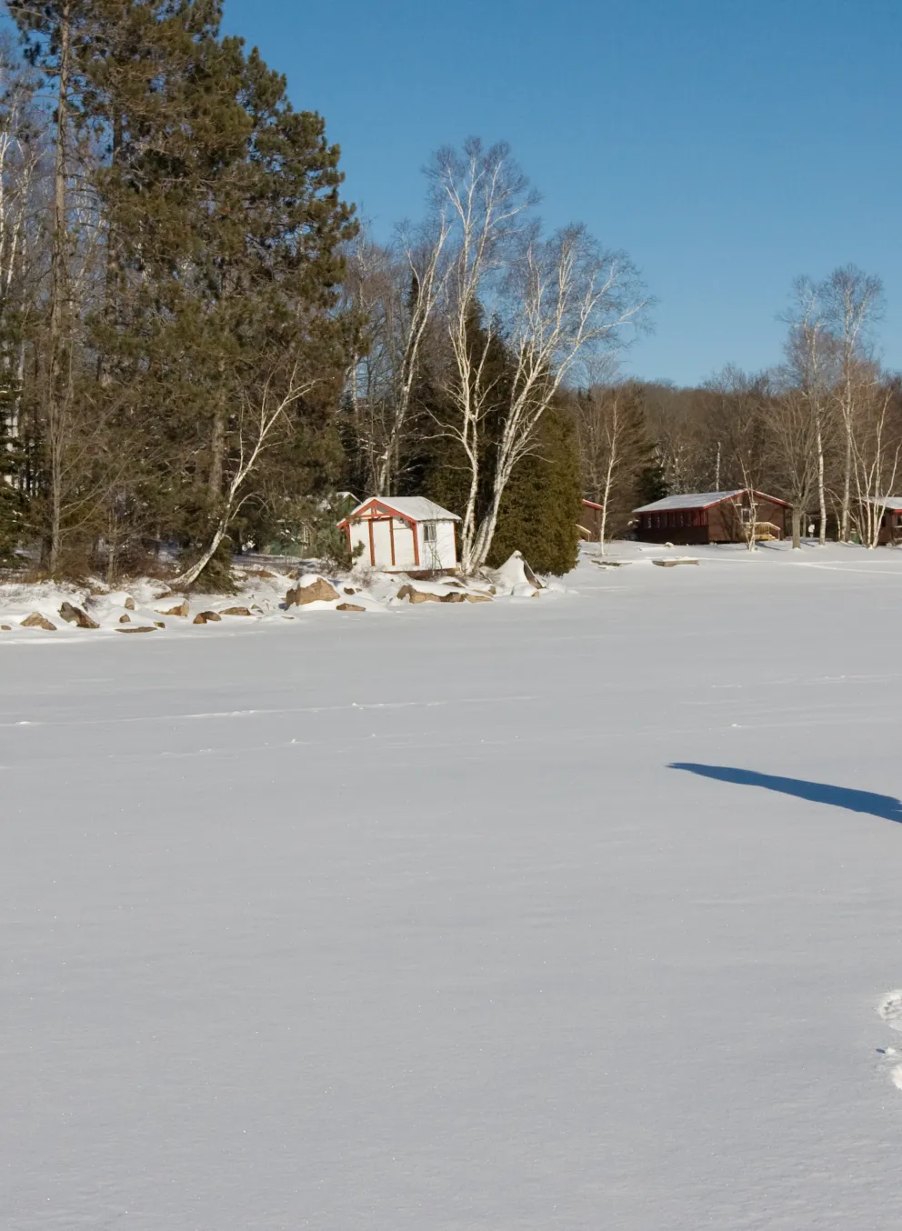 Snowshoer trekking across frozen lake