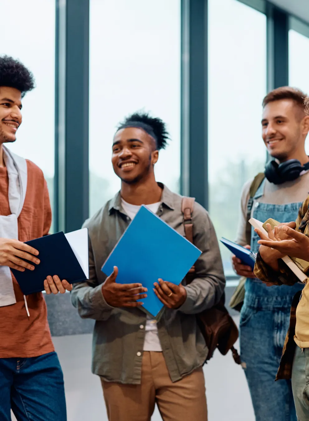 6 young people standing in a  circle talking, smiling.