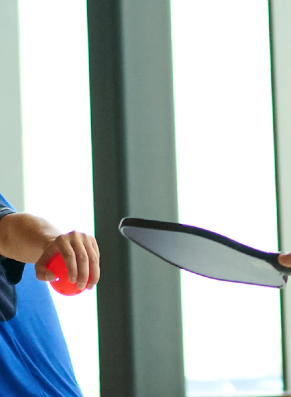 Two individuals playing Pickelball