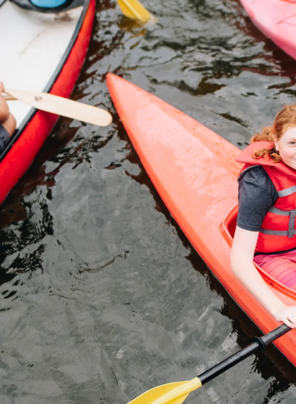 Kids in canoes on the water