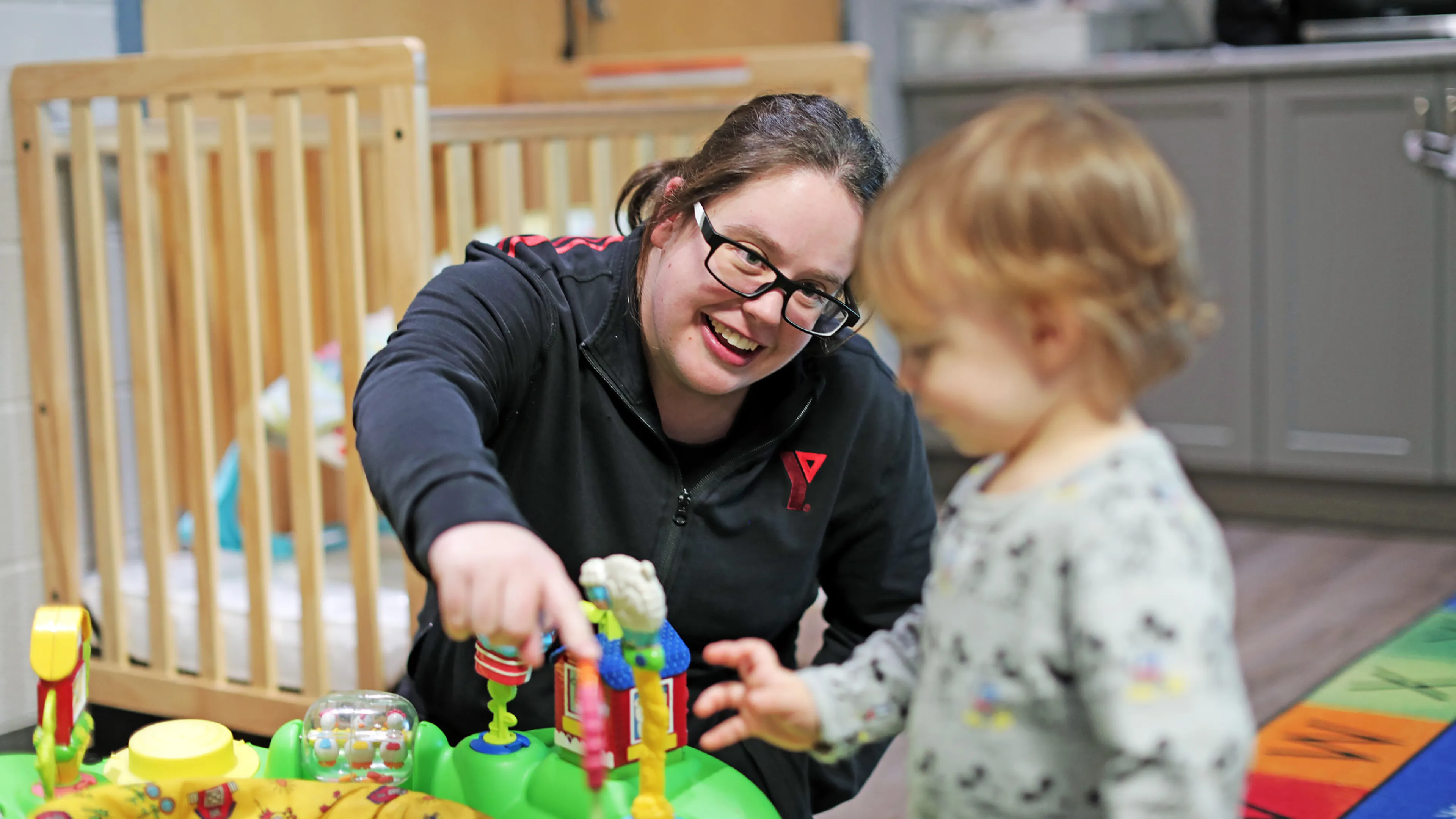 Male preschool child and Educator playing with colourful toys