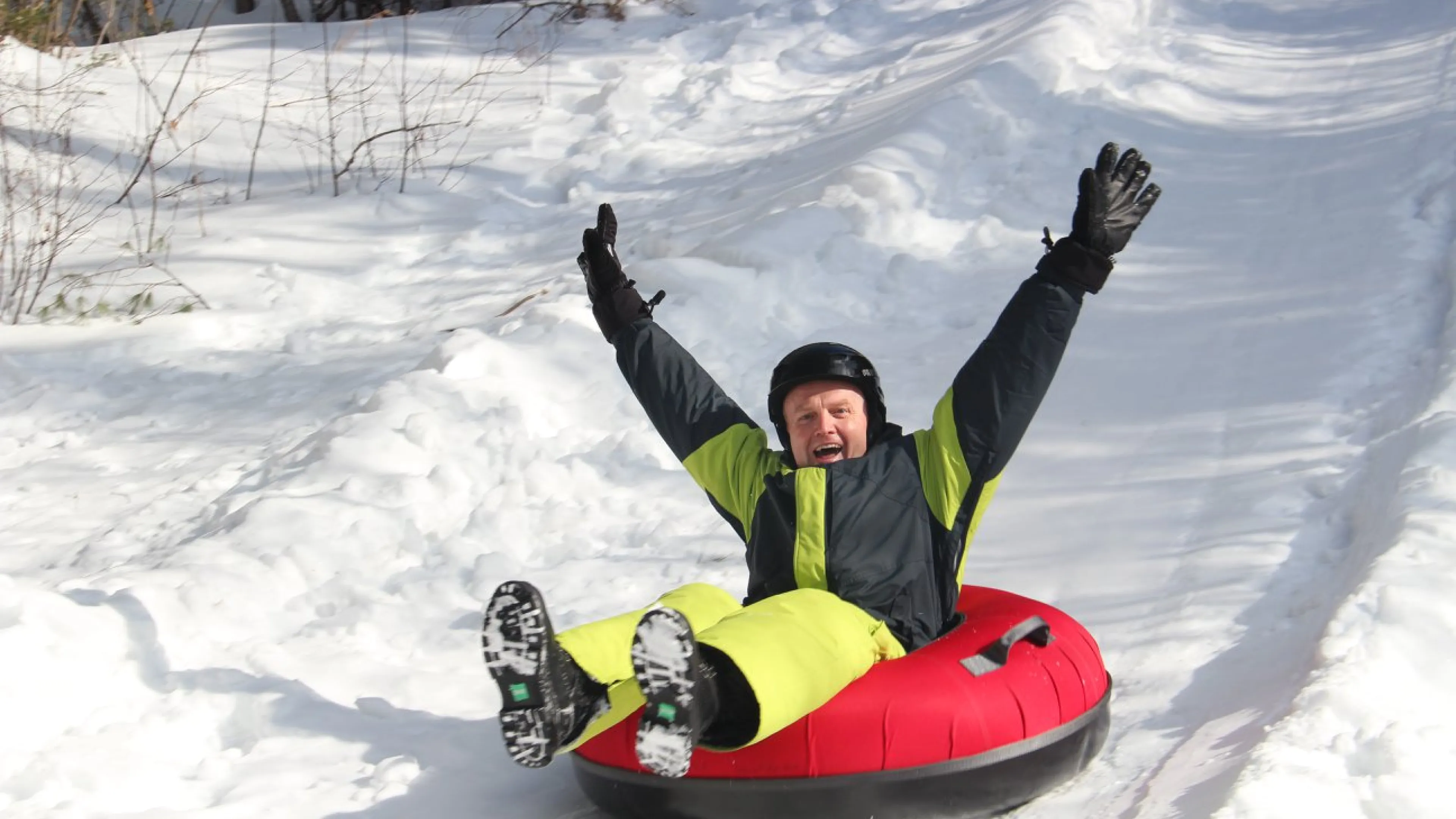 Adult tobogganing down hill