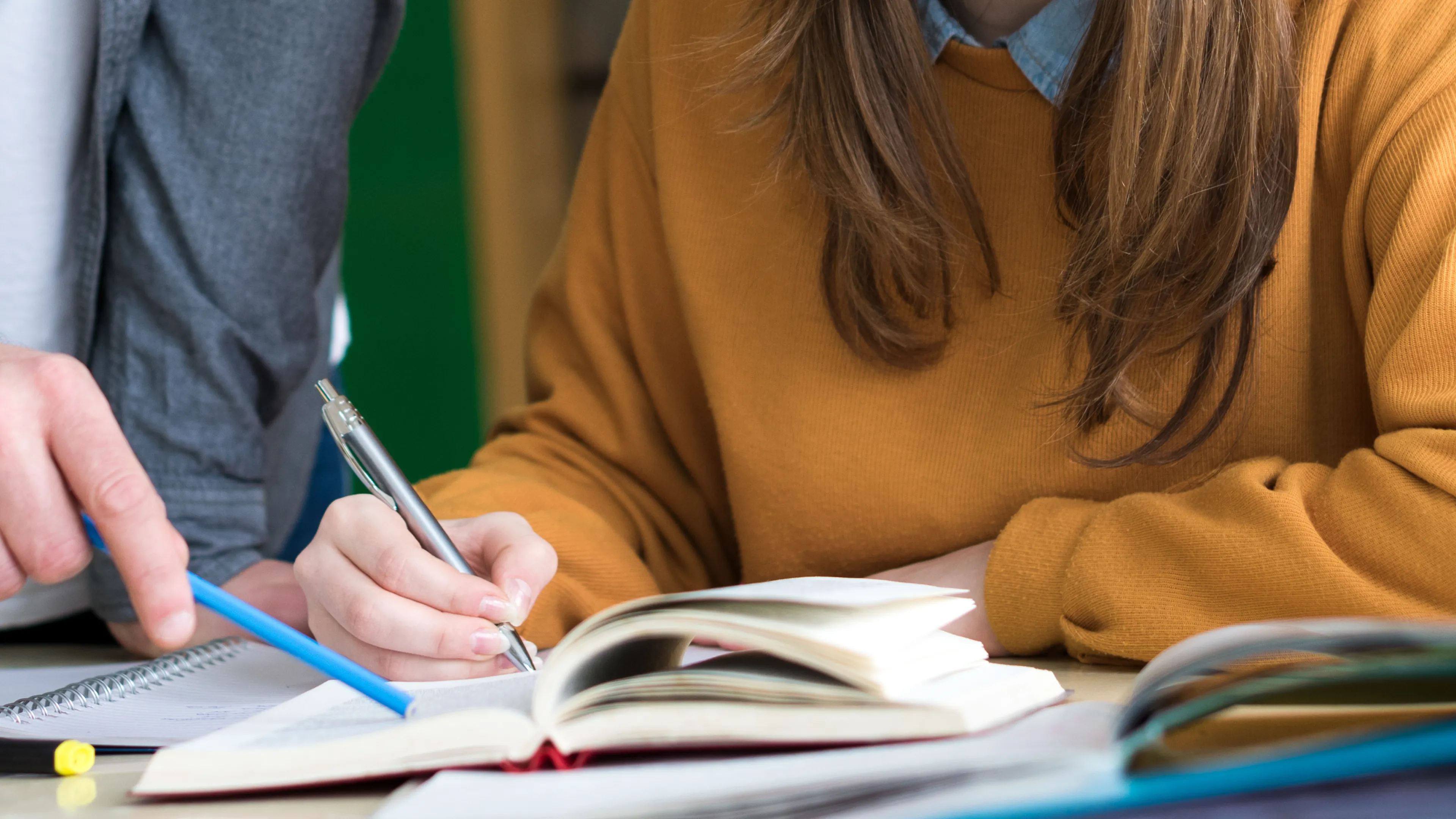 People are reading a notebook together
