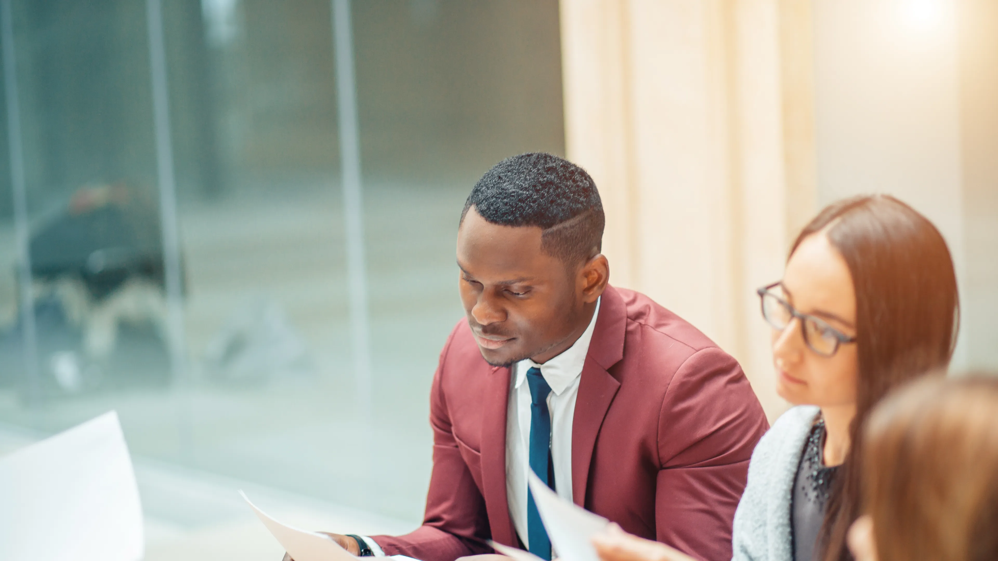 Two young people dressed professionally reviewing paperwork together