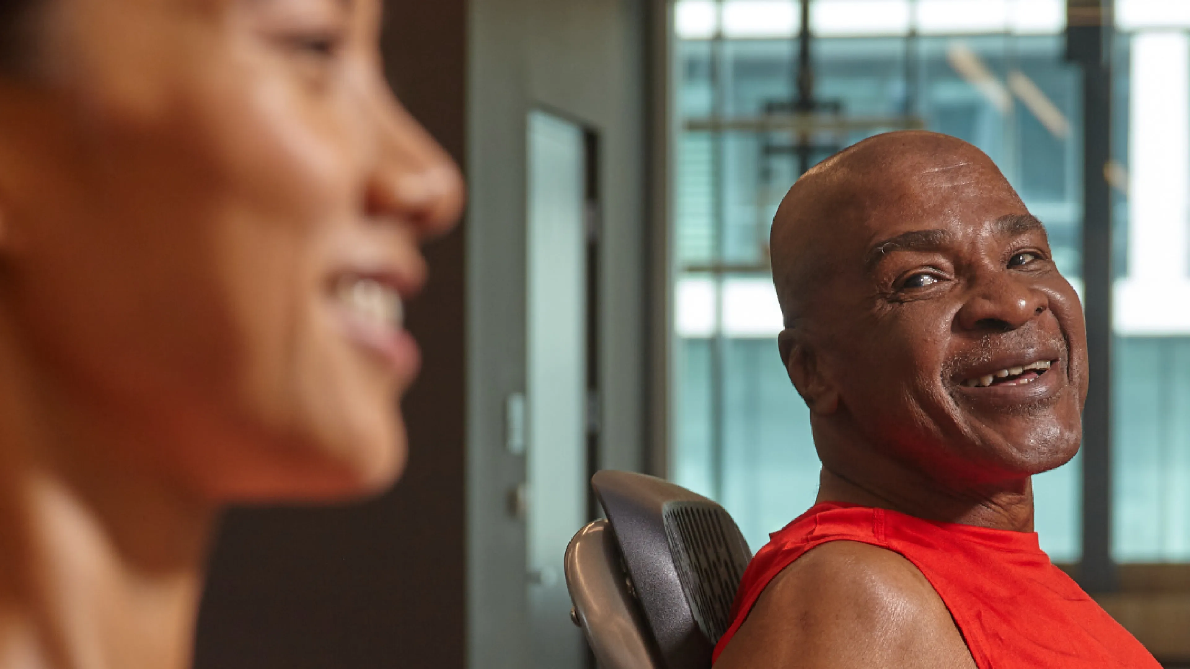 Two individuals smiling while at a gym