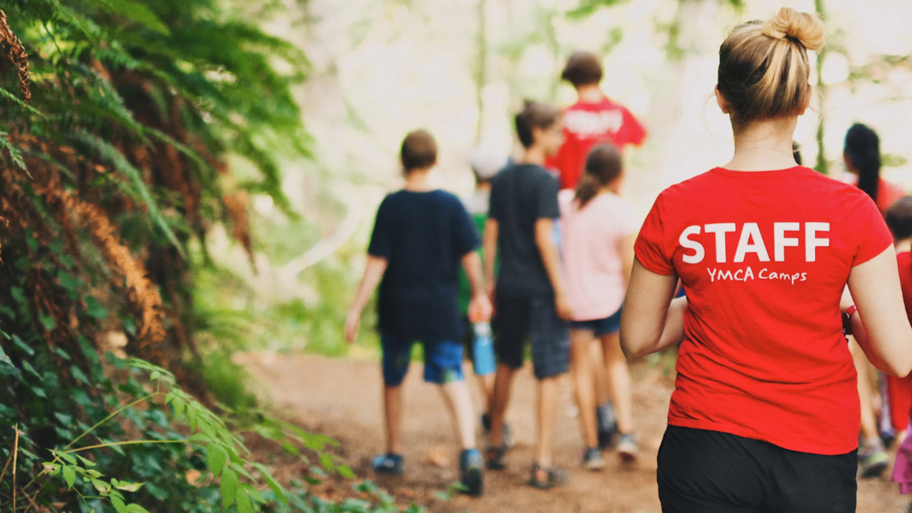 Camp councilors and kids walking down a path