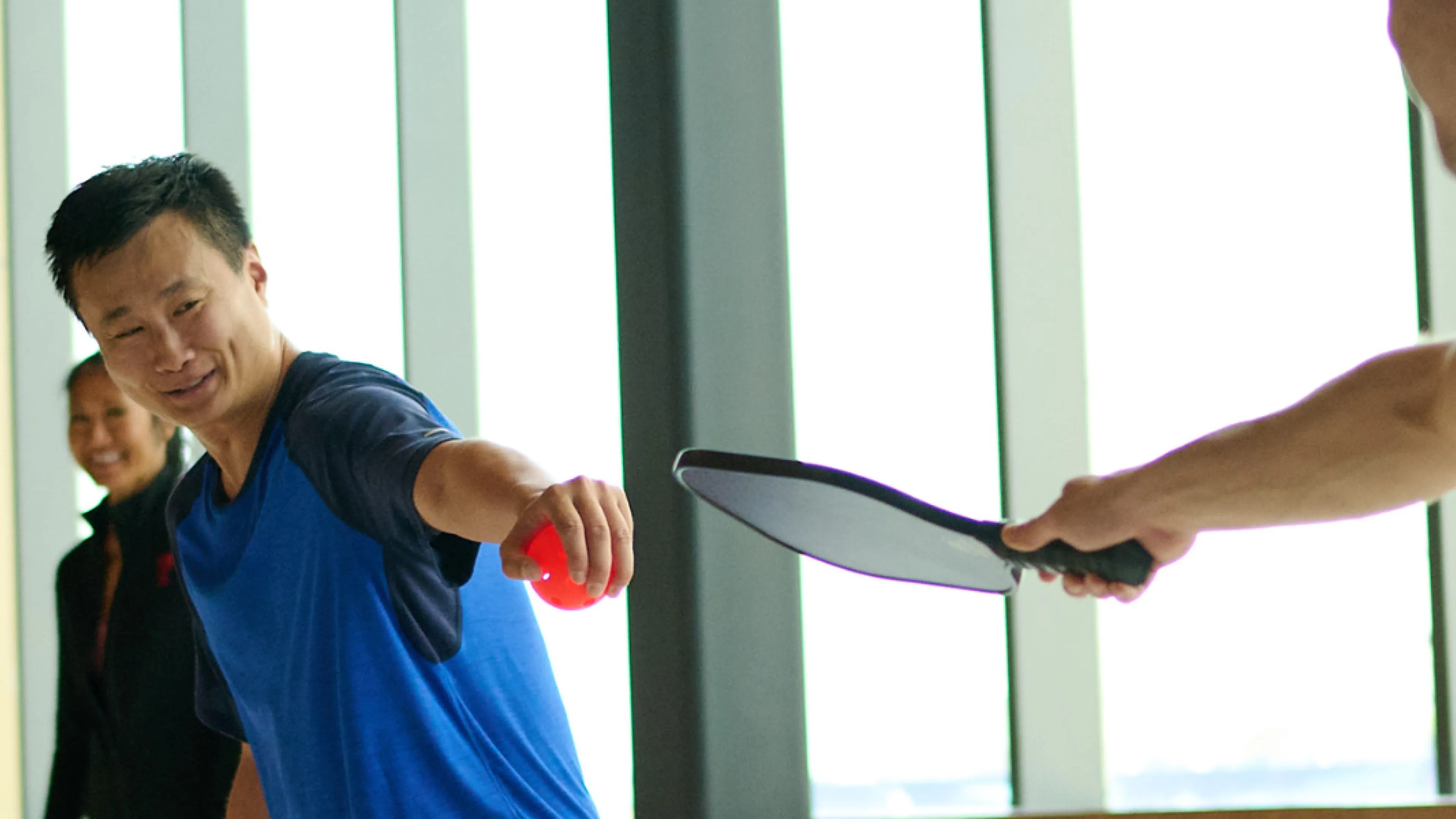 Two individuals playing Pickelball
